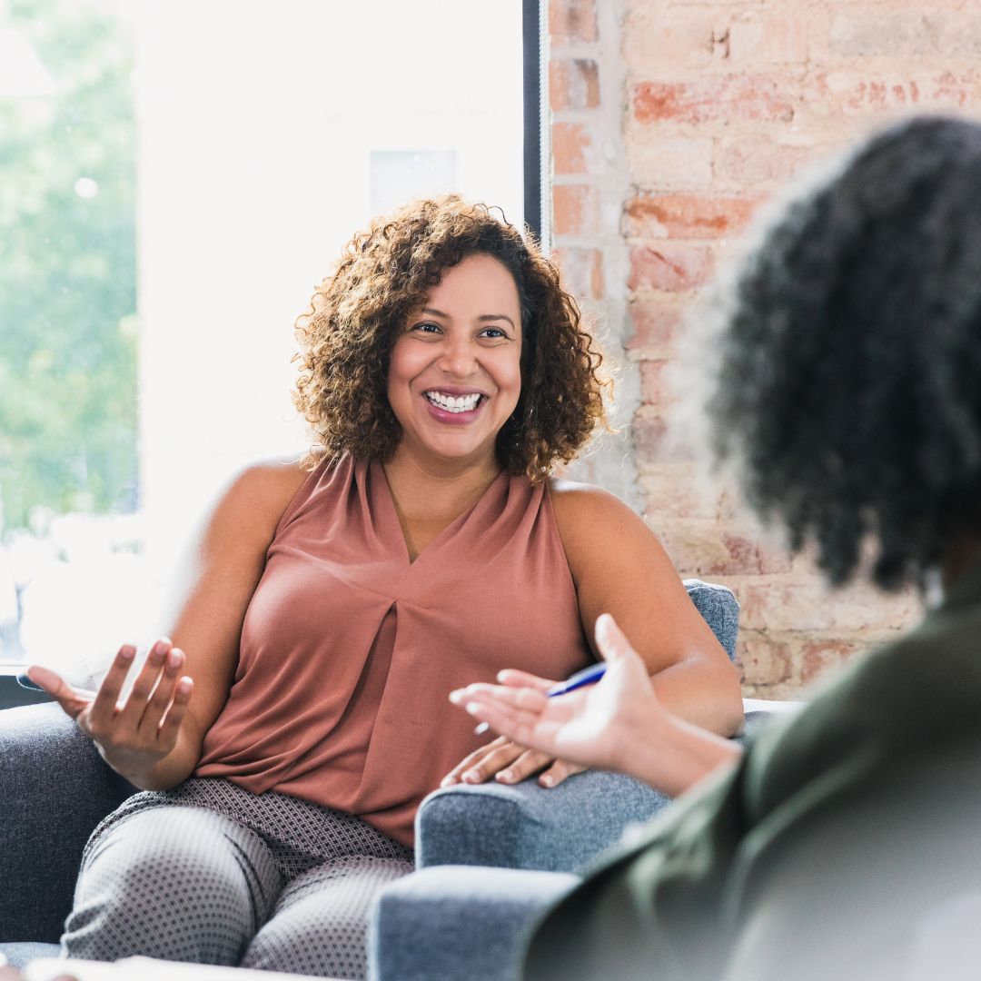 A woman smiling while talking to her therapist
